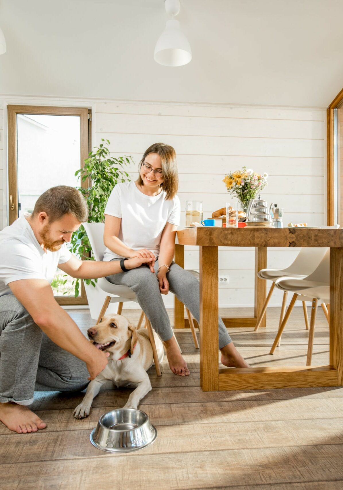 Happy couple with dog at home | T And H Floor Store